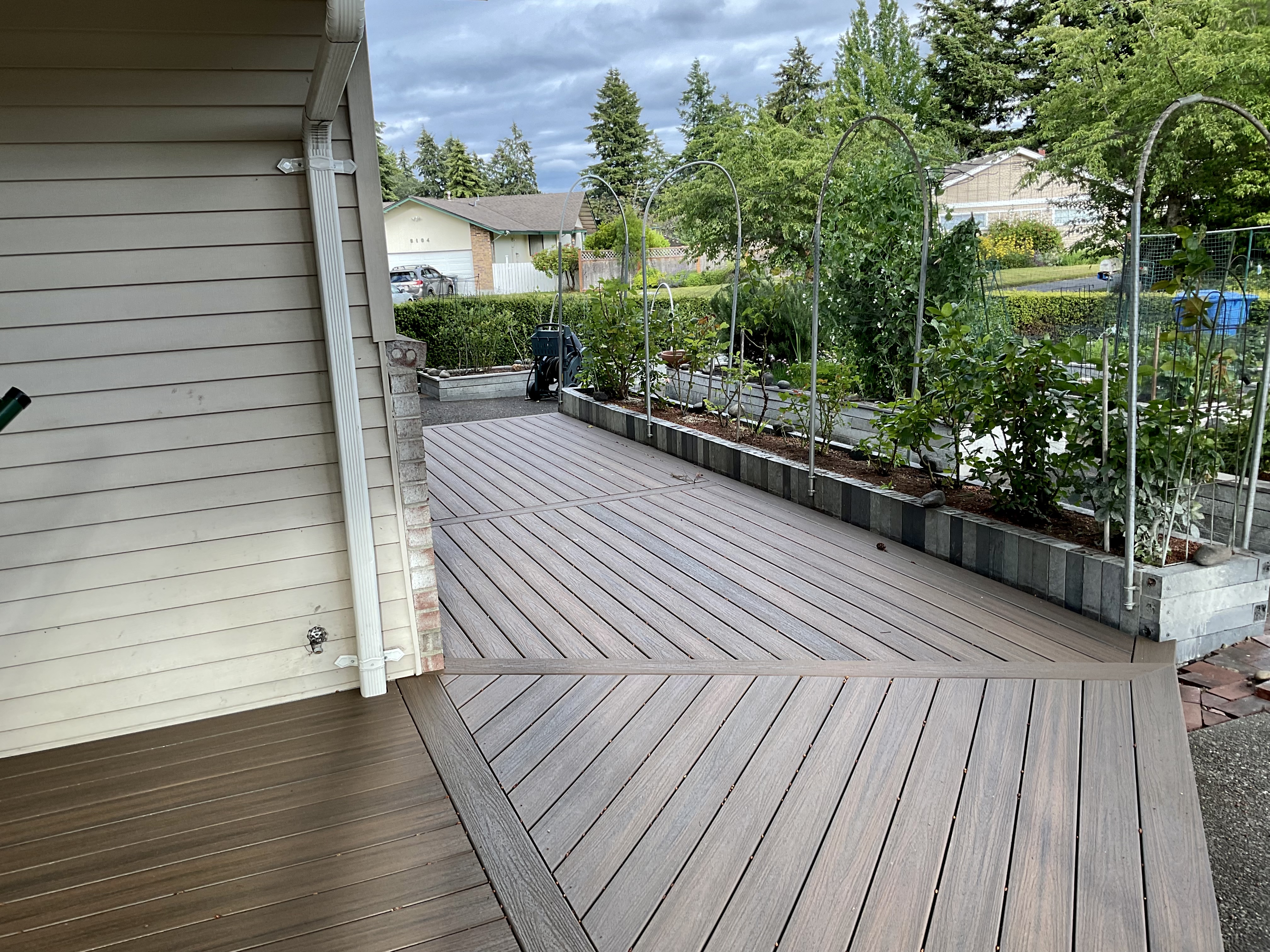 Finished Lakewood covered deck with timber-frame beams and black aluminum cable railing